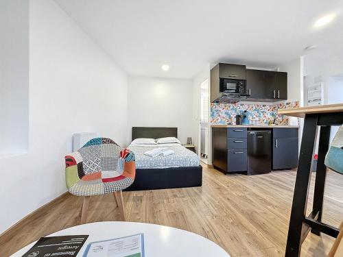 Cette petite chambre comprend un lit et une cuisine. dans l'établissement Ensemble 3 studios pour 6 personnes, à Royat