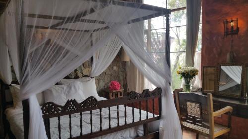ein Schlafzimmer mit einem Himmelbett mit weißen Vorhängen in der Unterkunft Family & Group Accomodation by Woodmere in Nairobi