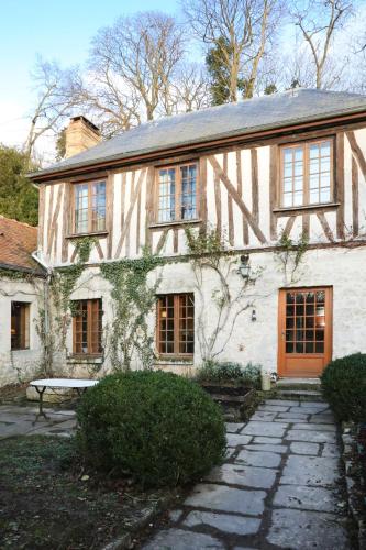 une vieille maison avec un banc devant elle dans l'établissement Made in Normandie by La boite en Plus, à Villers-Saint-Frambourg