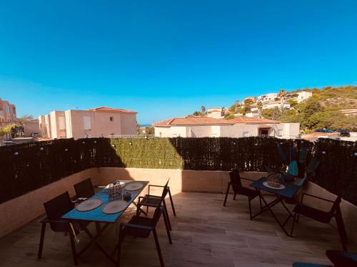 - deux tables et des chaises sur une terrasse avec vue dans l'établissement L effet mer, à Ajaccio