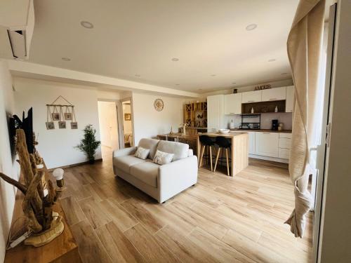 un salon avec un canapé blanc et une cuisine dans l'établissement L effet mer, à Ajaccio