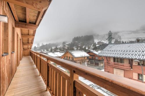 d'un balcon avec vue sur la ville dans la neige. dans l'établissement Duplex des Rois - Welkeys, à Megève
