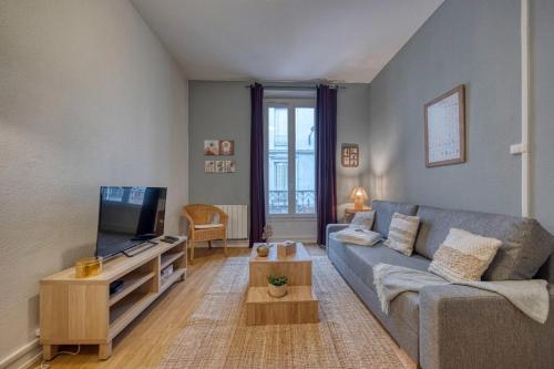 un salon avec un canapé et une télévision dans l'établissement #HI Le petit Marcel Hyper-centre fully equipped, à Grenoble