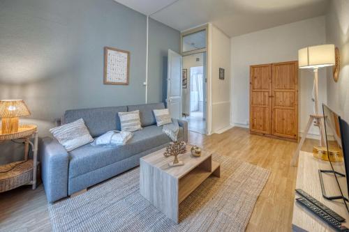 un salon avec un canapé bleu et une table dans l'établissement #HI Le petit Marcel Hyper-centre fully equipped, à Grenoble