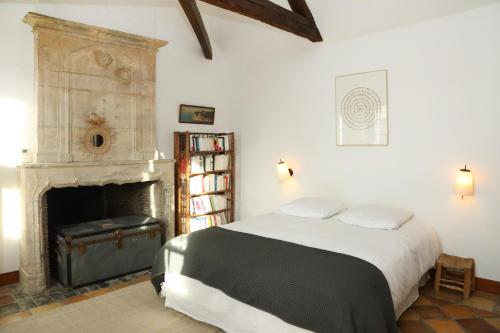 une chambre avec un lit et une cheminée dans l'établissement Made in Normandie by La boite en Plus, à Villers-Saint-Frambourg