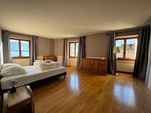 - une chambre avec un lit, du parquet et des fenêtres dans l'établissement Le nid montagnard - Vulmix, à Bourg-Saint-Maurice