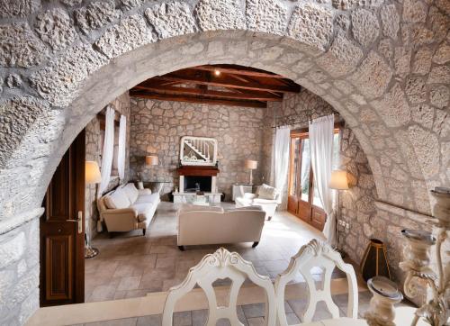 a living room with an arch in a stone wall at Villa Galini in Nydri