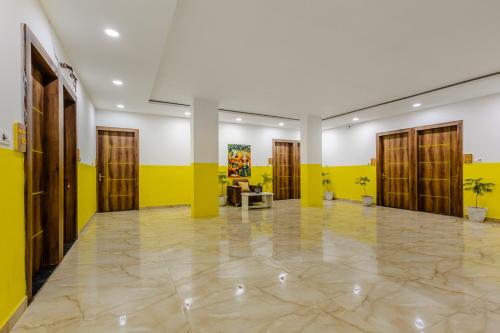 a lobby with yellow and white walls and wooden doors at Lime Tree Hotel and Banquet Vrindavan in Vrindāvan