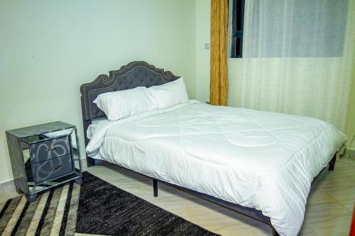 a bedroom with a bed with a night stand next to it at Pacific Times homestays in Ruiru
