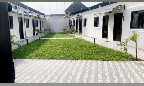 a courtyard of a house with a grass yard at Residence The Champion 2 in Ouidah