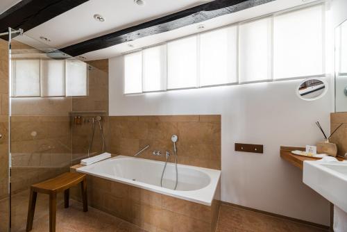 a bathroom with a tub and a sink at Neumühle Resort & Spa in Hammelburg
