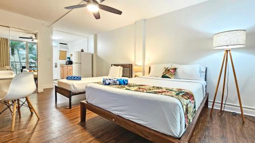 a bedroom with two beds and a ceiling fan at 2413 Kuhio in Honolulu