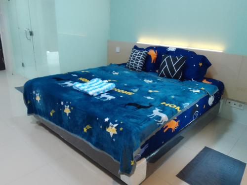 a bed with a blue comforter with animals on it at The Square - King Suite - Apartemen Service - 2Person - NetFlix Wifi - Near Petra Campus in Surabaya