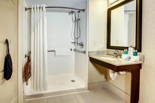 a bathroom with a shower and a sink at Holiday Inn Express - Neptune by IHG in Neptune City