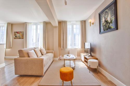 un salon avec un canapé et une table dans l'établissement de Funés, à Trouville-sur-Mer