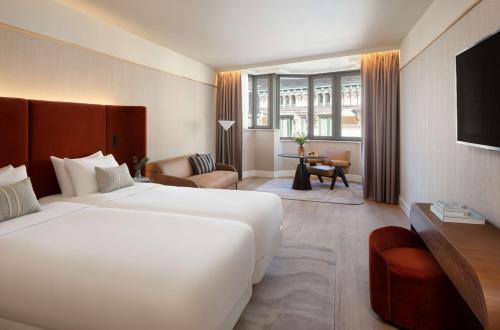 a hotel room with a large bed and a living room at NH Collection Gent in Ghent