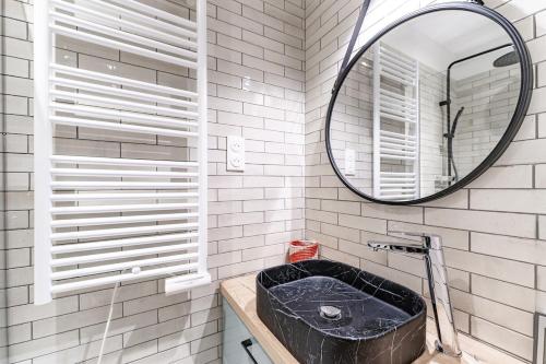 une salle de bain avec un lavabo noir et un miroir dans l'établissement Arcachon maison 2e ligne accès privé plage 50m, à Arcachon