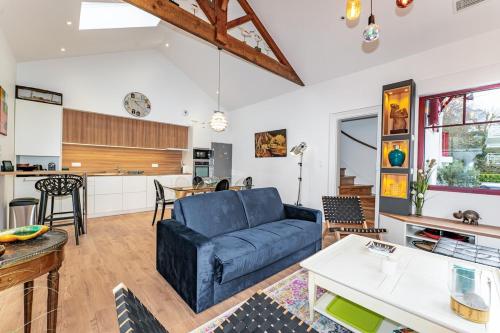 un salon avec un canapé bleu et une cuisine dans l'établissement Arcachon maison 2e ligne accès privé plage 50m, à Arcachon