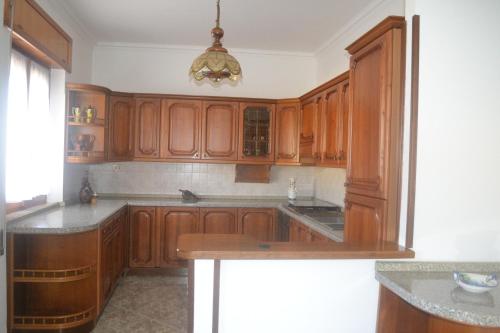 uma cozinha com armários de madeira e uma grande ilha em B&B Casa degli Ulivi em Nettuno