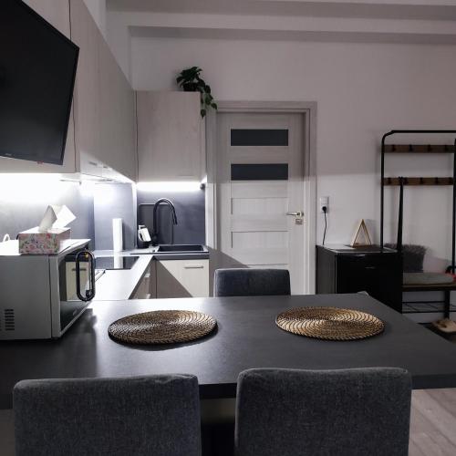 a kitchen with a table with chairs and a microwave at Apartament przy rynku w Szczebrzeszynie in Szczebrzeszyn