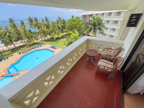 a balcony with a view of the pool and the ocean at Mombasa Continental Resort in Shanzu