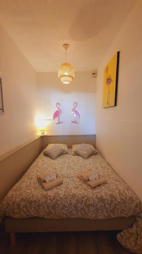 une chambre avec un lit avec deux oreillers dessus dans l'établissement T1bis INCAS Parking Clim Piscine - Centre-ville - ROSSIconciergerie - Linge inclus, à La Grande Motte