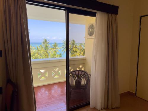 a room with a sliding glass door with a view of the ocean at Mombasa Continental Resort in Shanzu