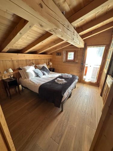 una camera da letto con un letto in una cabina di legno di Chalet La Pioleute Megève a Megève