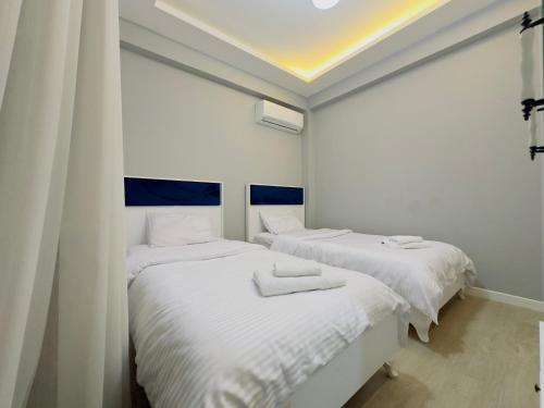 two beds in a room with white walls at Zümrüt villaları in Sapanca