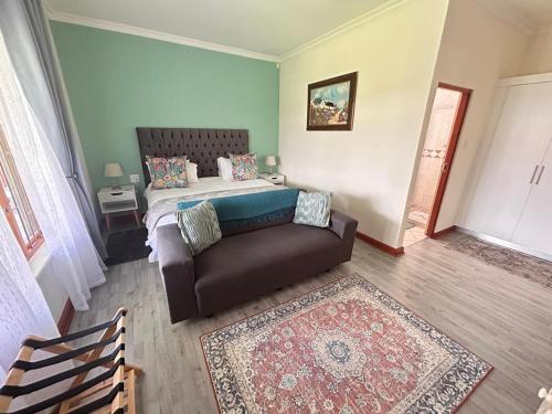 a bedroom with a bed and a couch at Mirihof Retreat and Olive Estate in Montagu