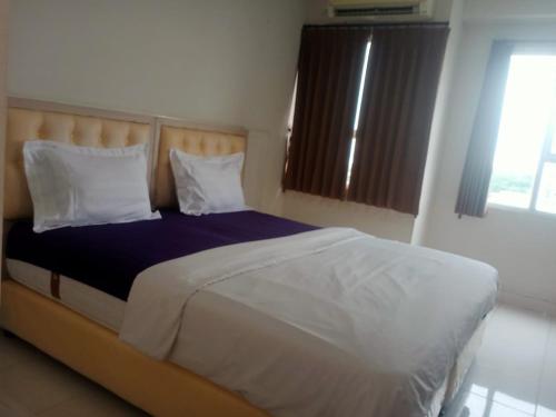 a bedroom with a large bed with two pillows at Apartment Elvis Tower Cikarang in Pegadungan