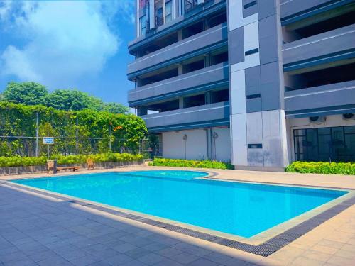 a swimming pool in front of a building at Apartment Elvis Tower Cikarang in Pegadungan