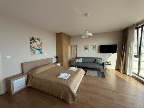 ein Schlafzimmer mit Bett und ein Wohnzimmer in der Unterkunft Boutique Home Magnolia in Goldstrand