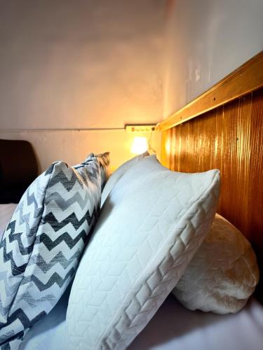 a bed with two pillows next to a wooden headboard at Kost Harian Semarang Murah in Semarang
