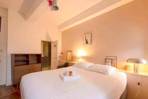 - une chambre avec un grand lit blanc et un plateau dans l'établissement Confort et charme au centre de Rennes, à Rennes