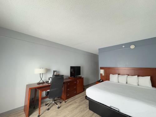 a bedroom with a bed and a desk and a computer at Super 8 by Wyndham Dallas Love Field Airport in Dallas