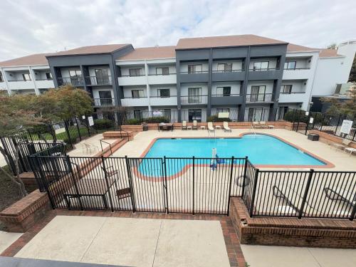 a large apartment building with a large swimming pool at Super 8 by Wyndham Dallas Love Field Airport in Dallas