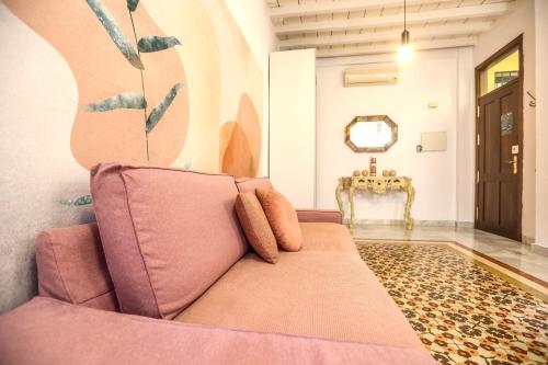 een woonkamer met een roze bank en een spiegel bij Malaga Dreams Oldtown FREE PARKING by Easytrip in Málaga