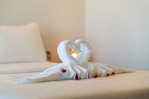 two swans sitting on top of a bed at Pomelo Outpost Cambodia ដំណាក់ភ្នំក្រោម in Phumĭ Rœssei Lŭk