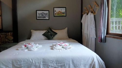 a bed with three bowls of flowers on it at Khmer Hands in Kep