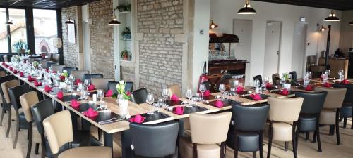 une longue salle à manger avec une longue table et des chaises dans l'établissement Hôtel de la GARE, à Saint-Gengoux-le-National