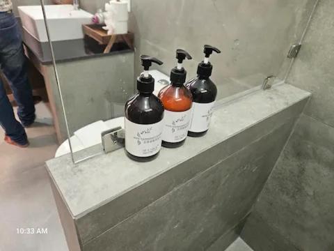 three bottles sitting on a counter in front of a mirror at 8 Bedroom Monkey Villa Room 201 in Amphoe Koh Samui
