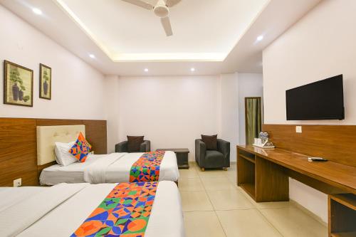 a hotel room with two beds and a flat screen tv at FabHotel Silver Oak BnB - Nr Yashobhoomi Convention Centre in Jāmb