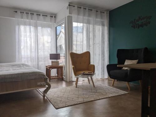 une chambre avec un lit, une chaise et une fenêtre dans l'établissement Joli studio proche des thermes, à Aix-les-Bains