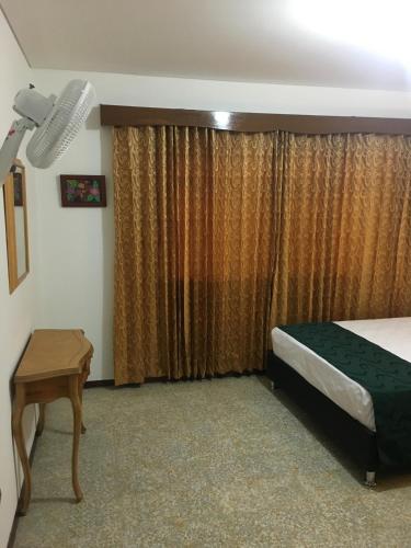 a bedroom with a bed and a table and a window at Finca Jerusalen in Tobia