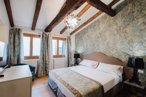 a bedroom with a bed and a desk with a television at Dimora Capuleti in Venice