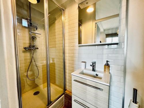une salle de bain avec douche et lavabo dans l'établissement L ESCALE, grand studio près de la gare, à Rennes