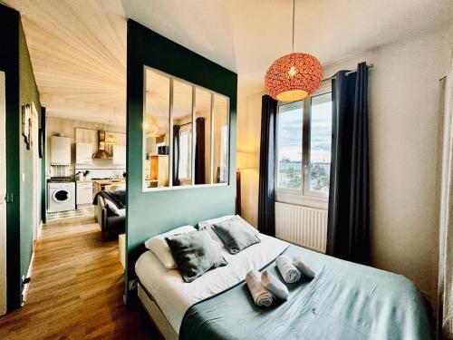 - une chambre dotée d'un lit avec un mur vert dans l'établissement L ESCALE, grand studio près de la gare, à Rennes