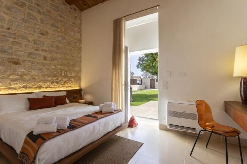 a bedroom with a bed and a brick wall at Villa Trifilla - IsulaTravel in Modica