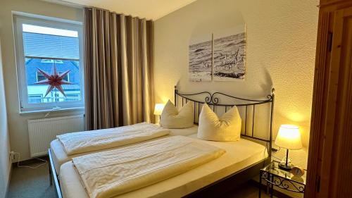 a bedroom with a bed with a large window at Ferienwohnungen Auf der Düne in Cuxhaven